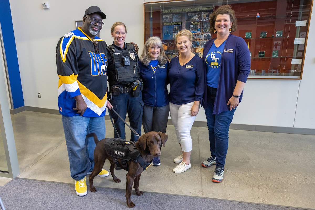 UAF Alumni stop by the Joseph E. Usibelli Building Atrium to visit after lunch and meet Yogi, the new UAF Campus Police K9 officer, during the Annual Nanook Rendezvous Alumni Reunion Campus Day on the UAF campus Friday afternoon, July 14, 2023. Pictured with Yogi from left are alumnus Darryl Lewis Sr., officer Jill Copeland, alumnus Lorna Shaw, UAF Alumni Association vice president Rhonda Widener, and UAF Alumni Relations director and UAF Alumni Association executive director Theresa Bakker.