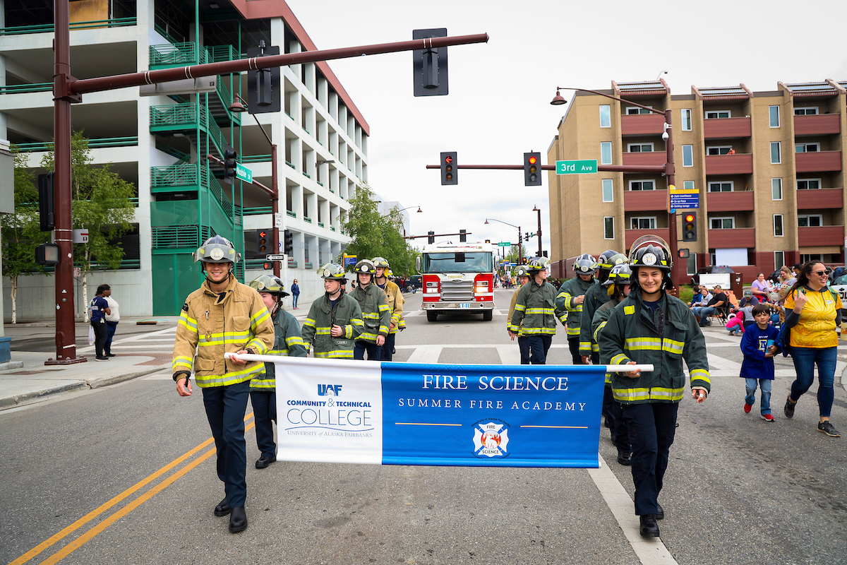 Students of the UAF CTC Fire Academy walk the streets of downtown Fairbanks as part of Nanook Nation during the 2023 Golden Days Parade.