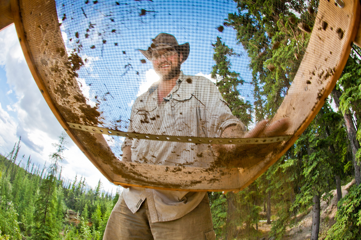 Joey Sparaga sifts dirt through a sieve while participating in an archeological field camp  at a dig site near Delta Junction. | UAF Photo by Todd Paris