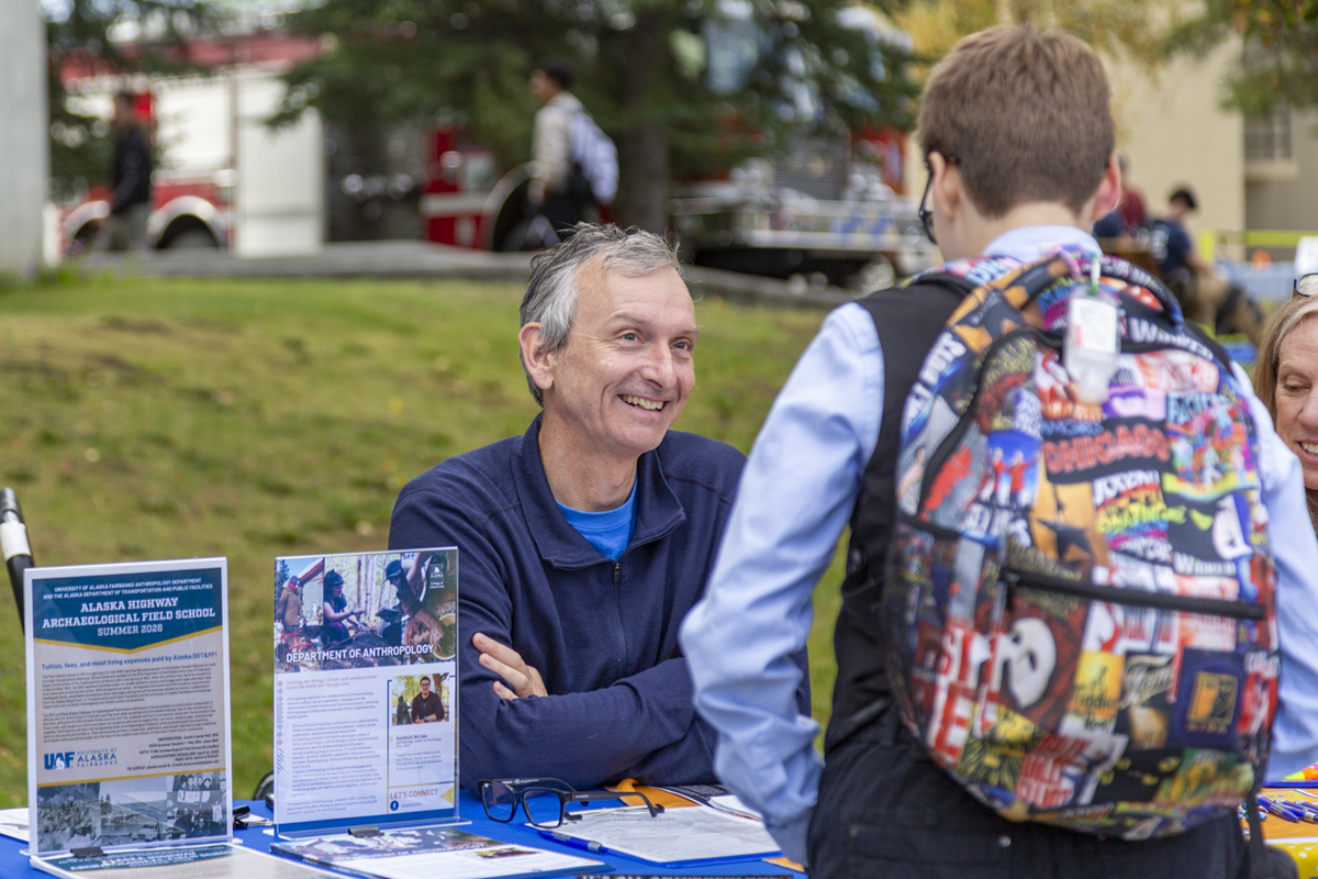 Patrick Plattet welcomes new UAF students at the Anthropology table at 2025 Party in the Park. UAF Photo by Sarah Manriqez