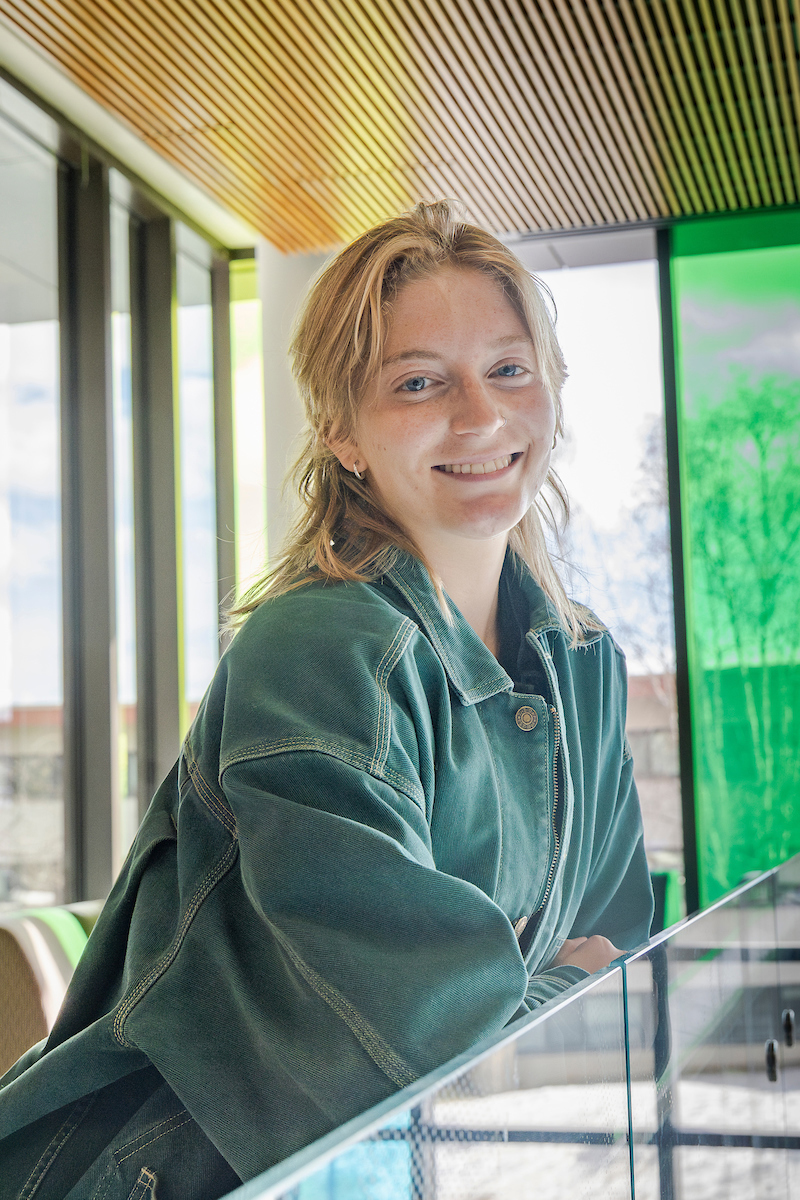 Hazel Probst, a recipient of the 2025 College of Liberal Arts' Department of Anthropology Outstanding Student Award take their portrait in the Wood Center, April 18th, 2025. (UAF photo by Leif Van Cise)