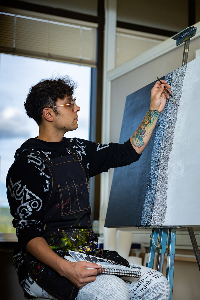 UAF Senior Kyle Augustines paints his thesis project in the painting studio of the Fine Arts Building. (UAF Photo by Leif Van Cise)