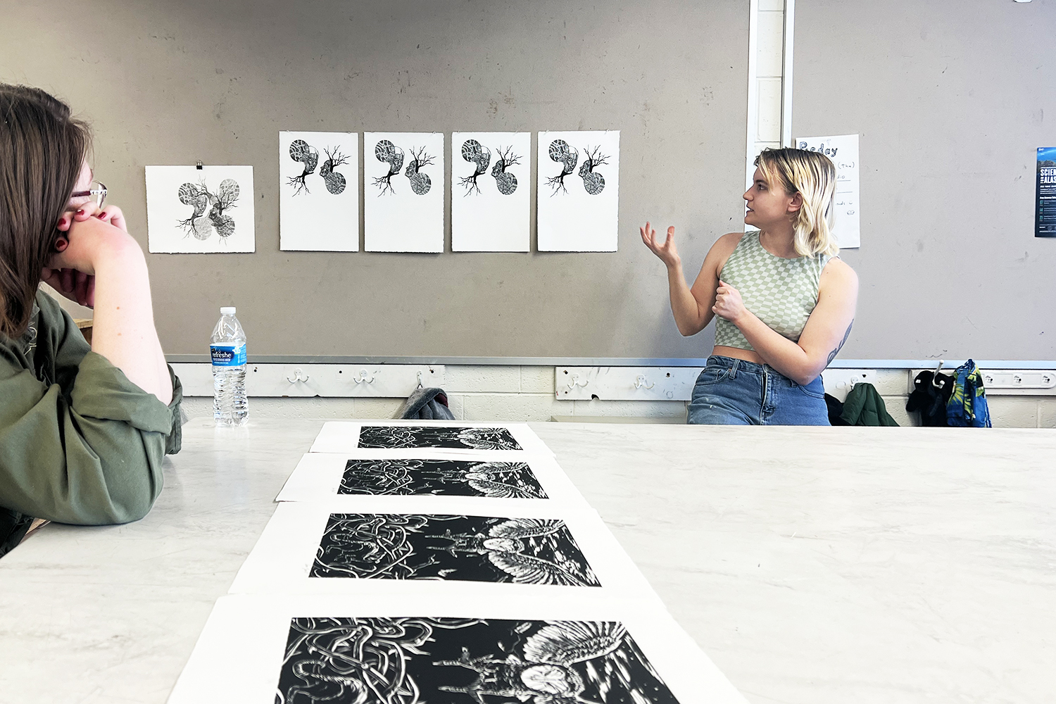 A student presents her series of black and white prints to her printmaking class for critique