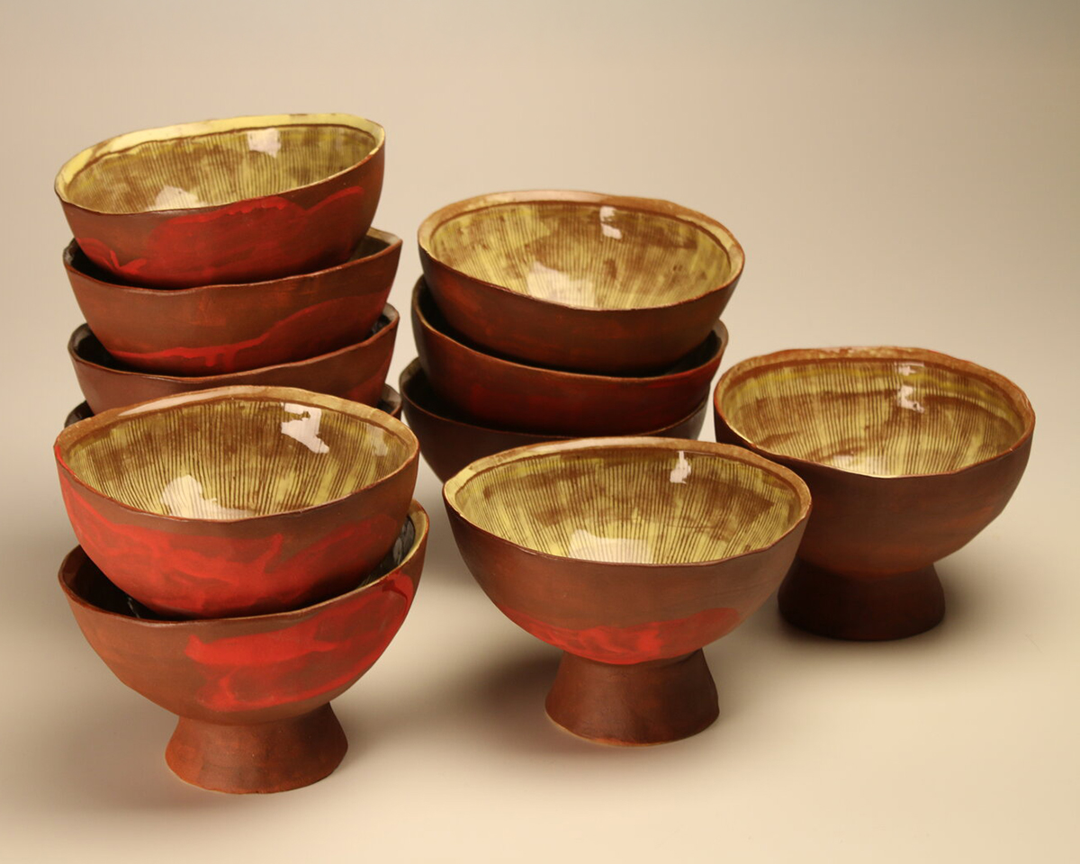 A series of small red stacked bowls by Sara Hensel
