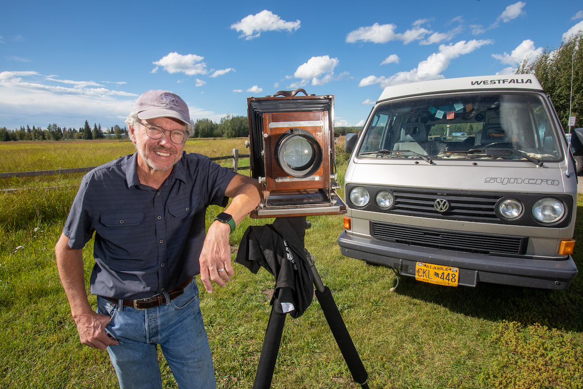 Charles Mason poses with his 8X10 camera and VW Syncro Westfalia Vanagon at Creamer's Field Wednesday, August 17, 2022. UAF Photo by Eric Engman