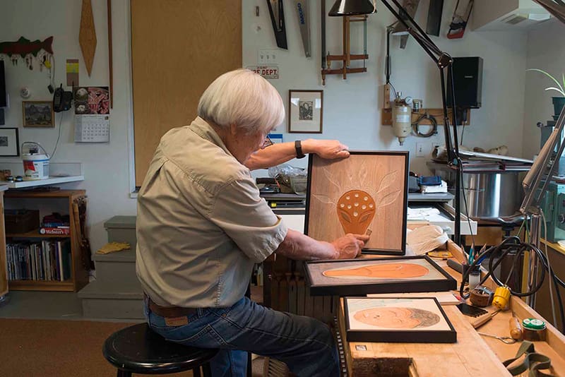 Ron Senungetuk working on one of his wooden panels, June 2015. Photograph by Sven Haakanson.