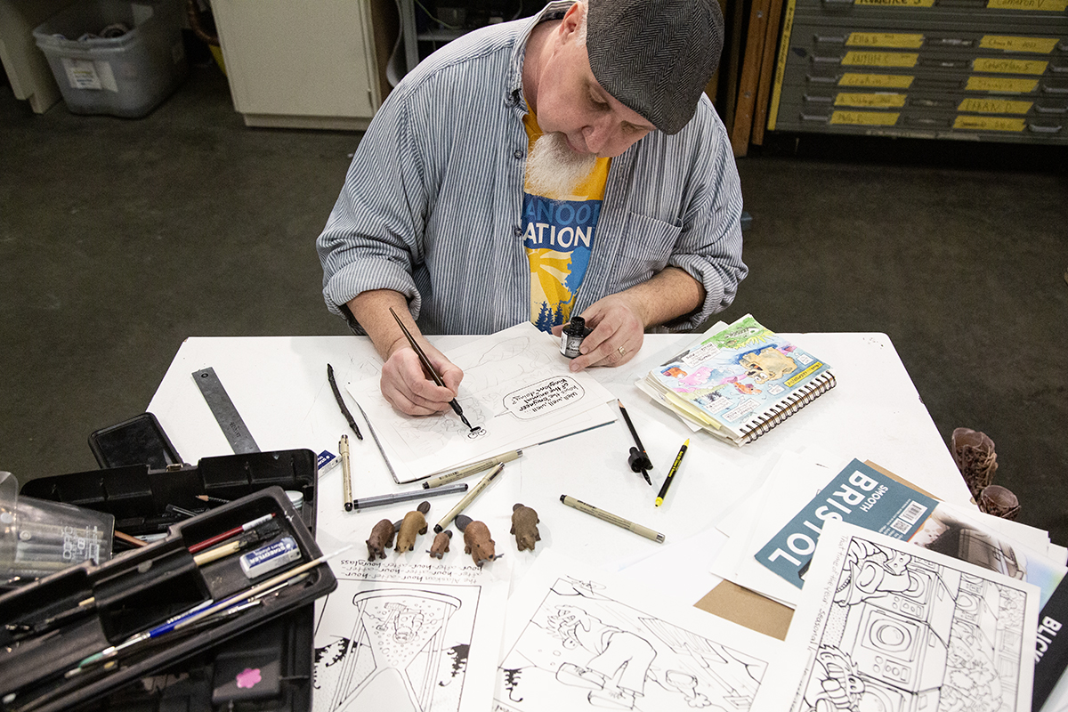 Jamie Smith inking his comic, Nuggets. UAF Photo by Sarah Manriquez