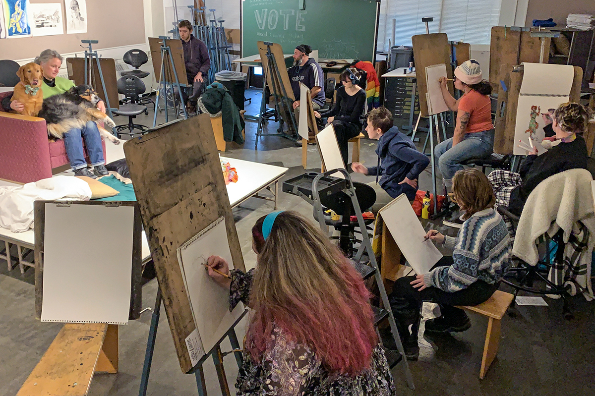 Students in a drawing class sketch a visiting model with her dogs. Photo courtesy of the UAF Department of Art