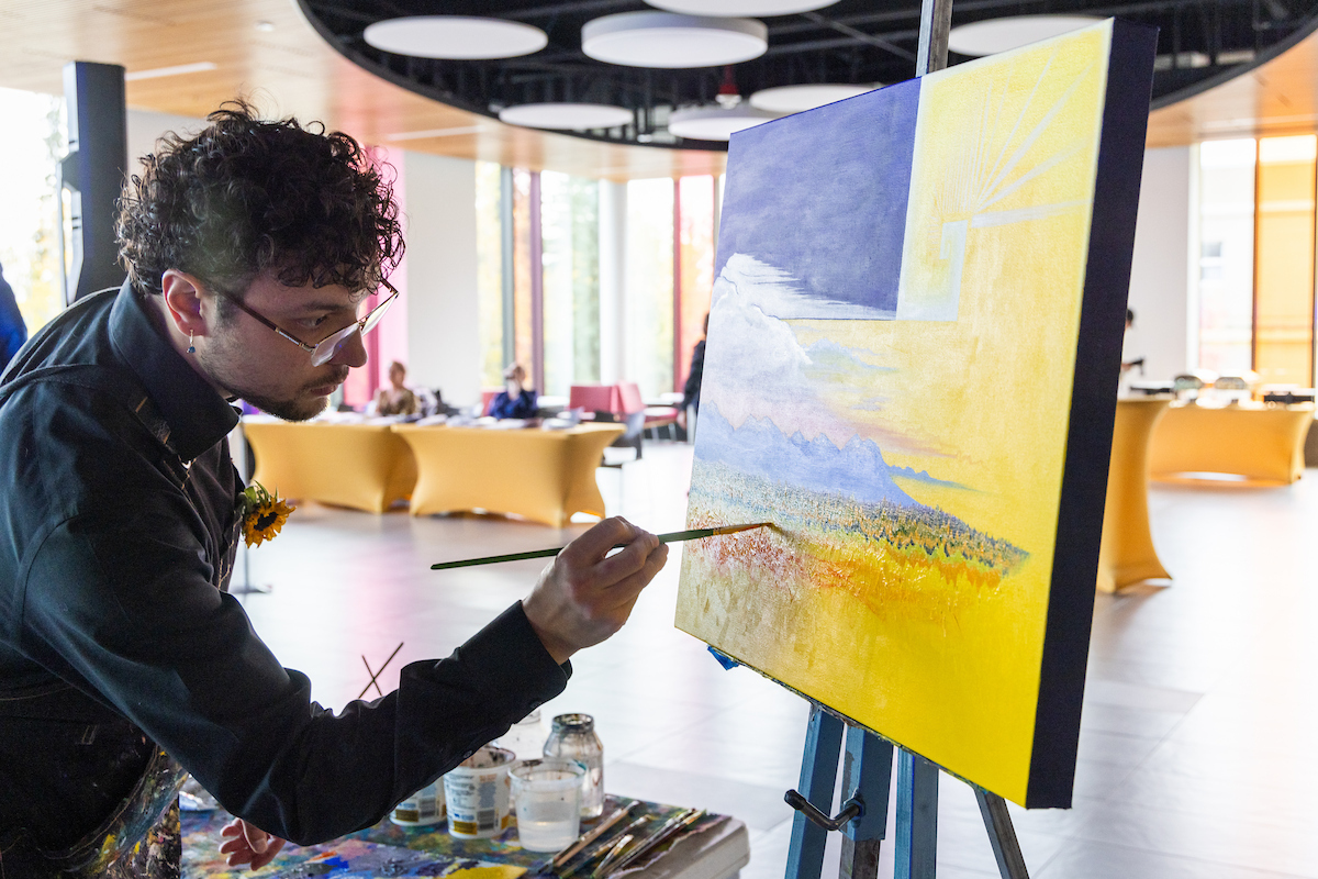 Kyle Agustines puts the finishing touches on his painting that was auctioned off at the Blue & Gold Banquet and Fundraising Auction at Dine 49 on the UAF campus Saturday, September 14, 2024. UAF Photo by Eric Engman