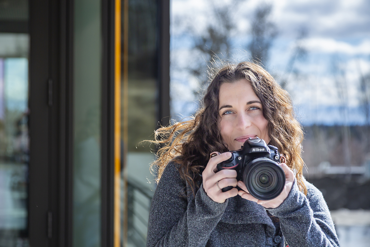 Jaylon Pate '25 Art, poses with her camera in the UAF Wood Center. UAF Photo by Sarah Manriquez