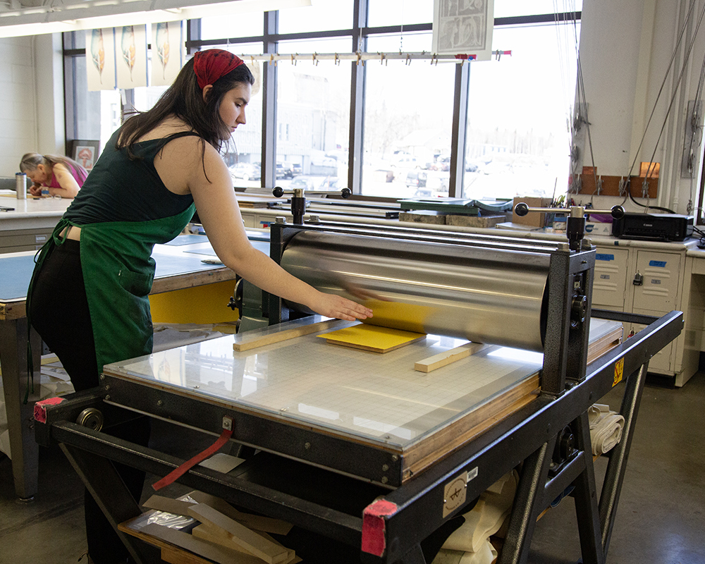 Jade Lamoreaux situates her woodblock on the printing press.