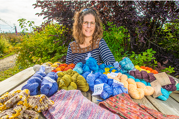 Melissa Shippey displays some of her custom-dyed yarn and knitting in August 2022 at the Georgeson Botanical Garden on the UAF Troth Yeddha' campus. UAF photo by Eric Engman.
