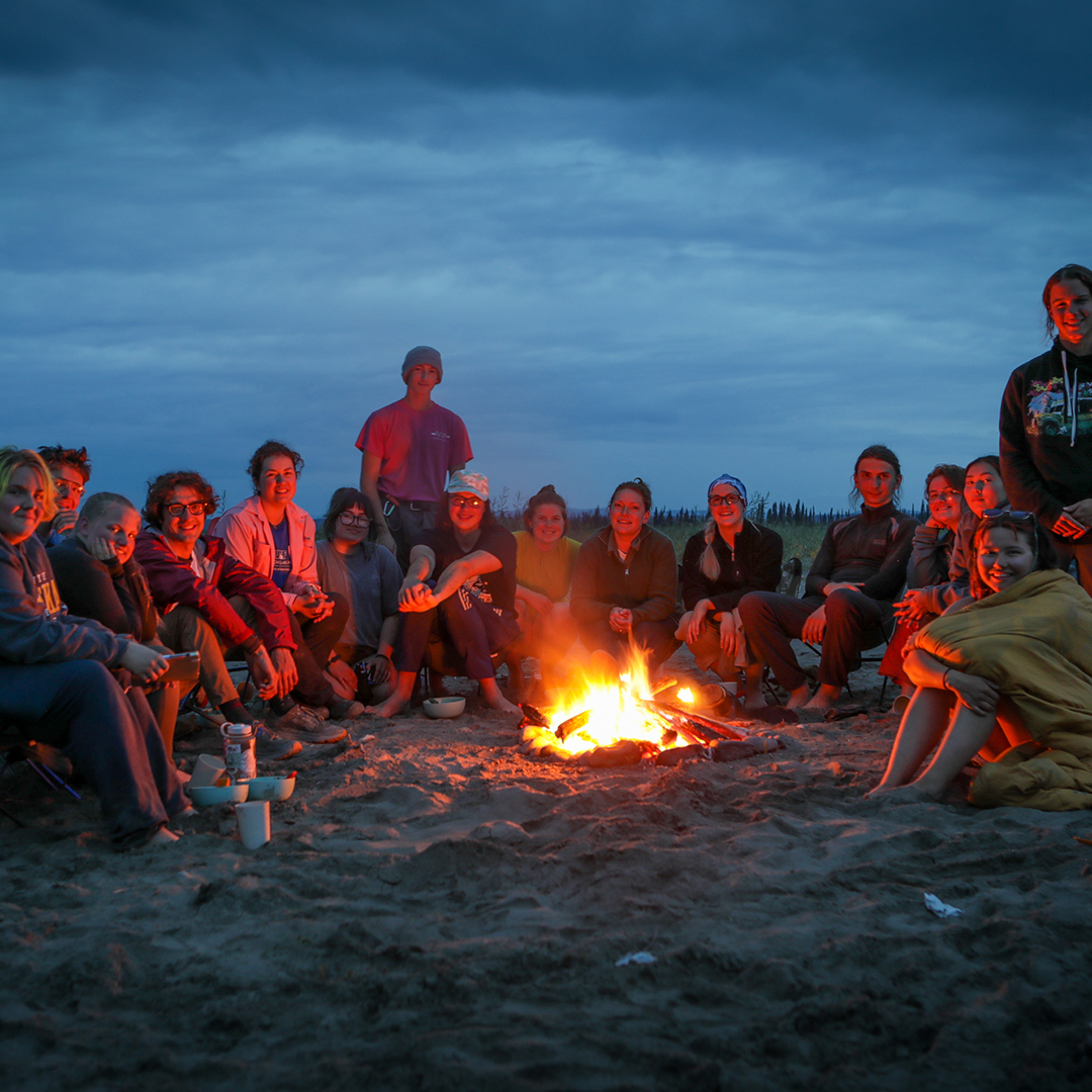 Photo by Dirk Rohrbach.
During a Yukon River float trip in summer 2023, UAF climate scholars enjoy an evening fire at their campsite on a sandbar.