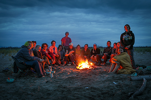 Yukon River float participants and instructor Bathsheba Demuth of Brown University enjoy an evening campfire at their campsite on the sandbar. Photo by Dirk Rohrbach.