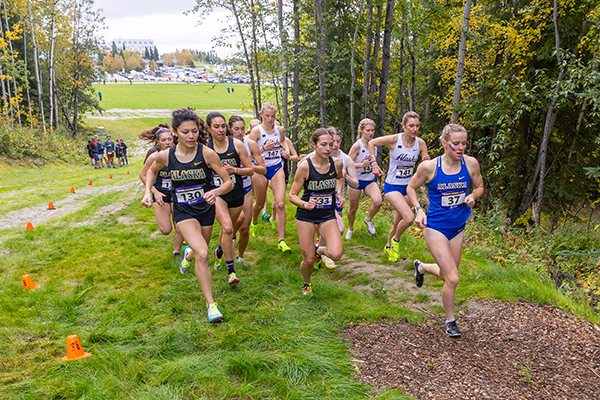 Rosie Fordham, right, leads the pack of runners up the first hill of the 3-lap, 6K women's course as University of Alaska Fairbanks cross-country runners compete in the Blue & Gold race against University of Alaska Anchorage the morning of Sept. 13, 2025, on the UAF Competition Trails.