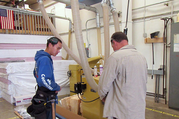 Construction trades students watches an equipment demonstration