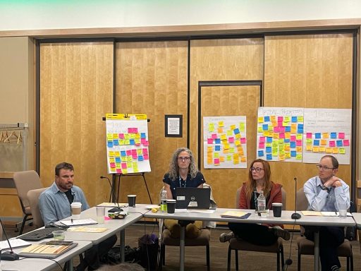 A group sits at a conference tabe. 