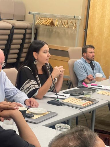 A group sits at a conference tabe. 
