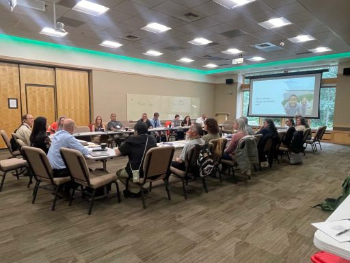 A wide angle view of a conference room with a group seated at a table.