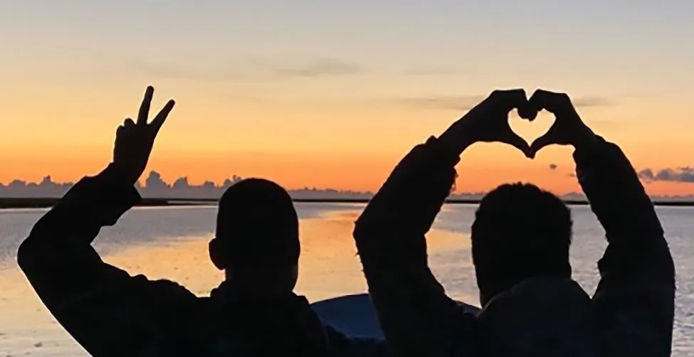 Young people standing in the glow of he sunset