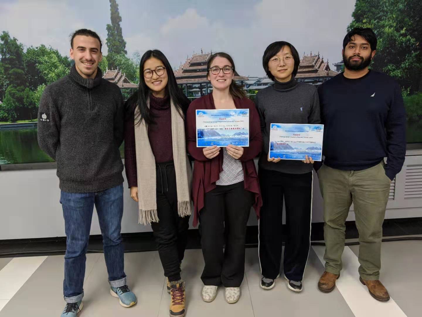 Five students stand holder award certificates