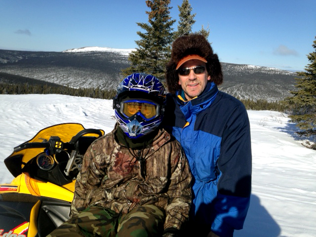 Tim snow-machining with his son, Jesse