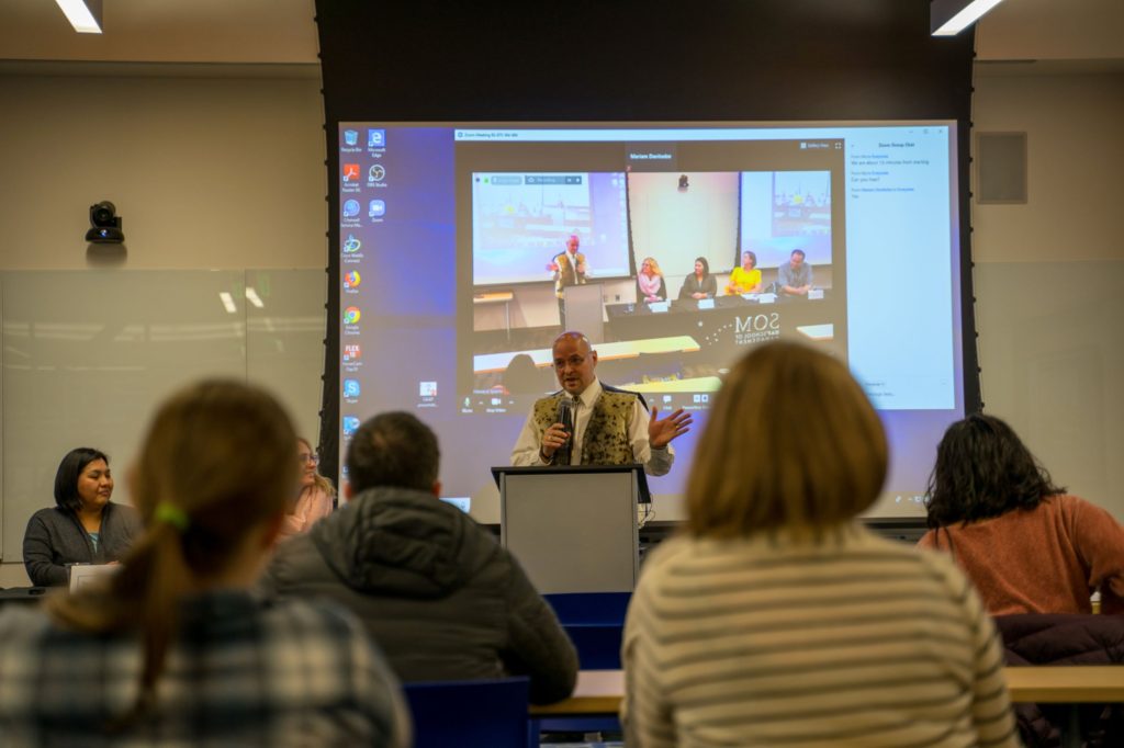 speaker presents at podium to classroom