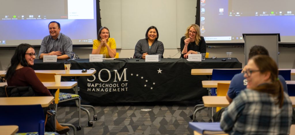 panel speaks to audience at SOM School of Management table