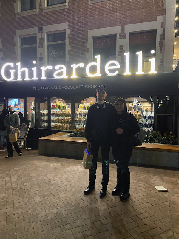 Two students outside on street in front of a shop