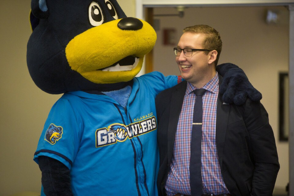 Travis with the Kalamazoo Growlers Mascot. Prior to the Hornets, Travis worked for the Kalamazoo Growlers, a summer collegiate baseball league team within the Northwoods League in Kalamazoo, Michigan. 