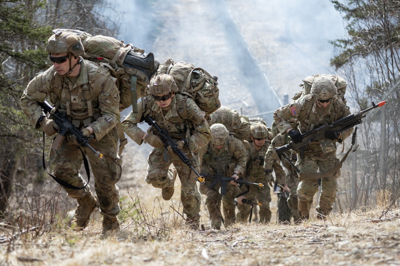 soldiers in uniform, with backpacks and guns on a mission
