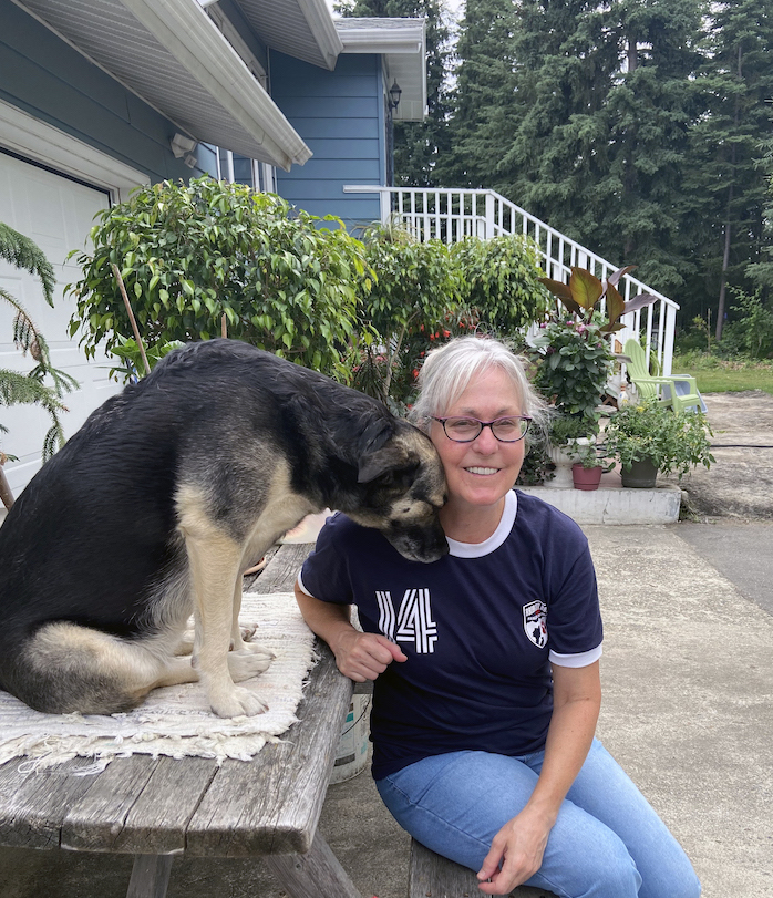 woman poses with her dog nestling into her neck