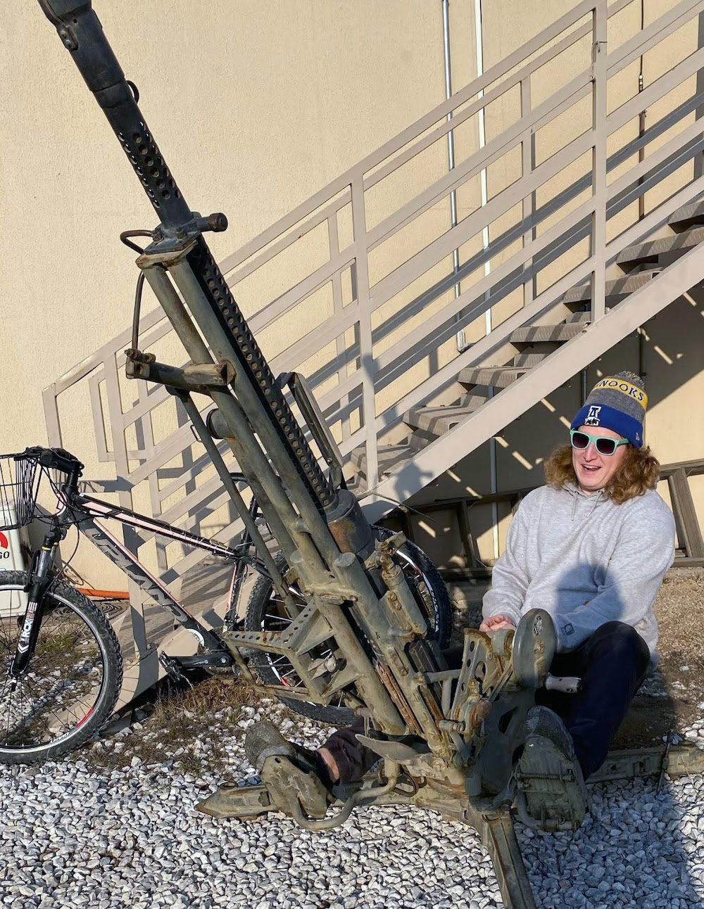 man smiling posing with large gun 
