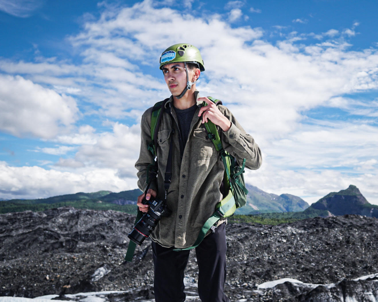 Man stood atop a glacier in full climbing gear