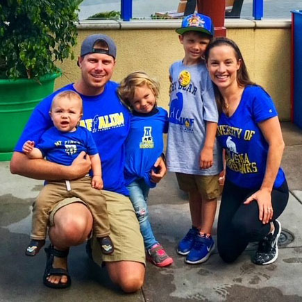 mom, dad and three young children smile for photo