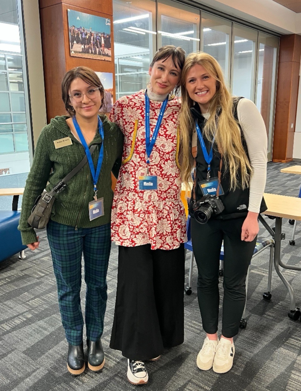 Three women pose together wearing Media badges
