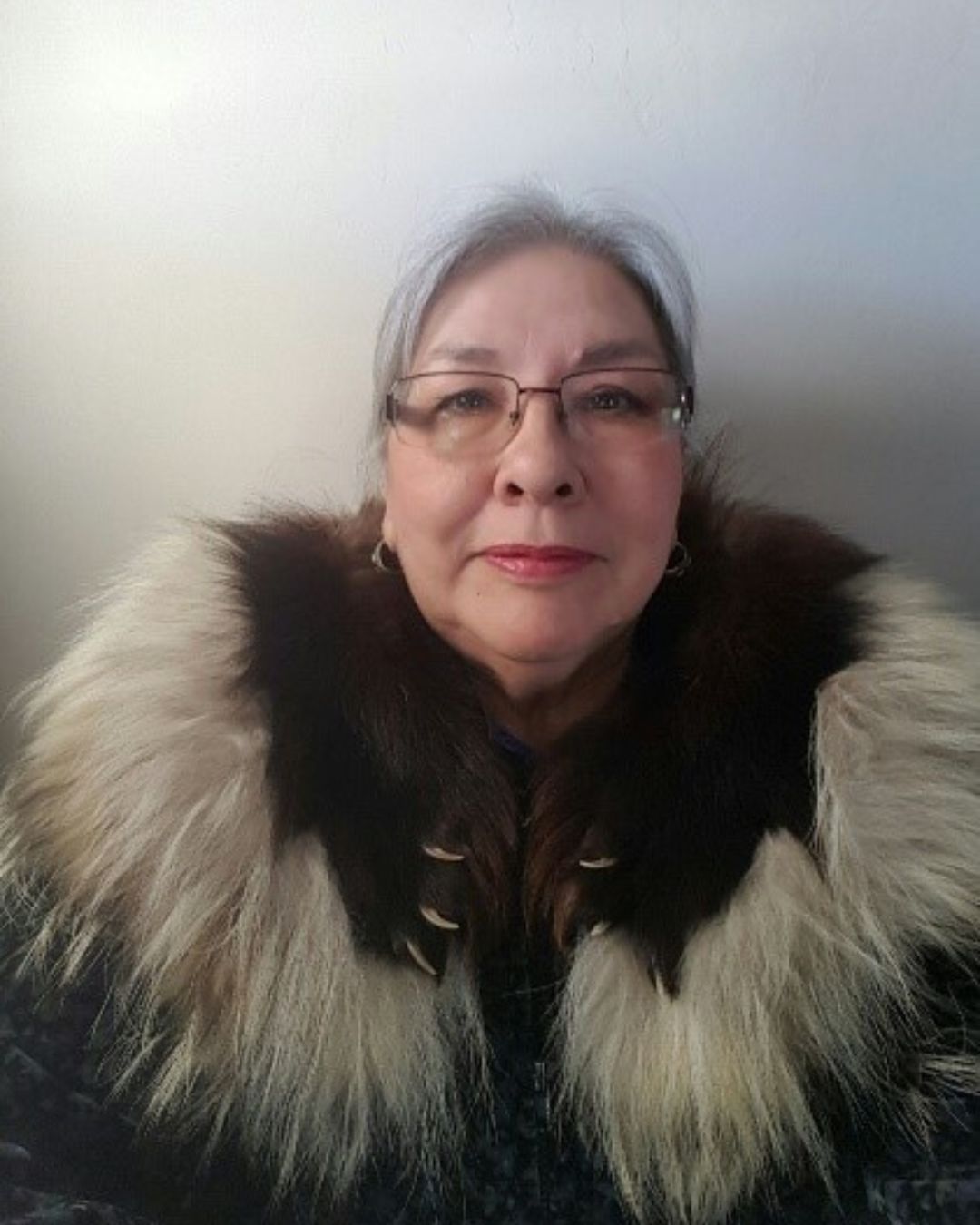 Woman smiles wearing a fur parka in close up portrait