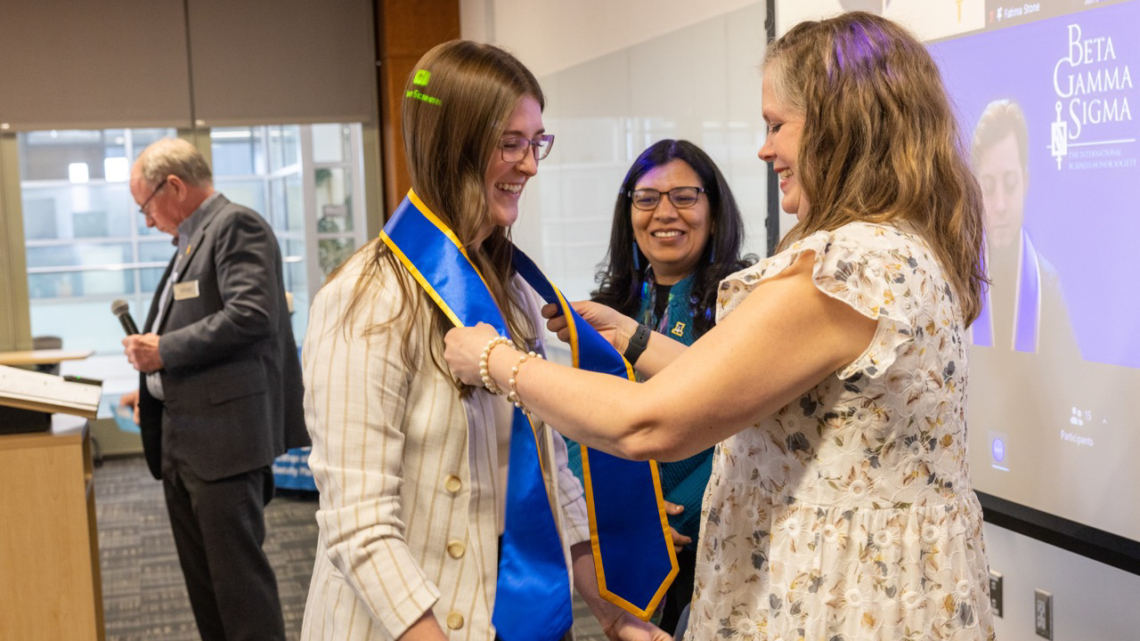 Meghan receives sash at honors society induction.