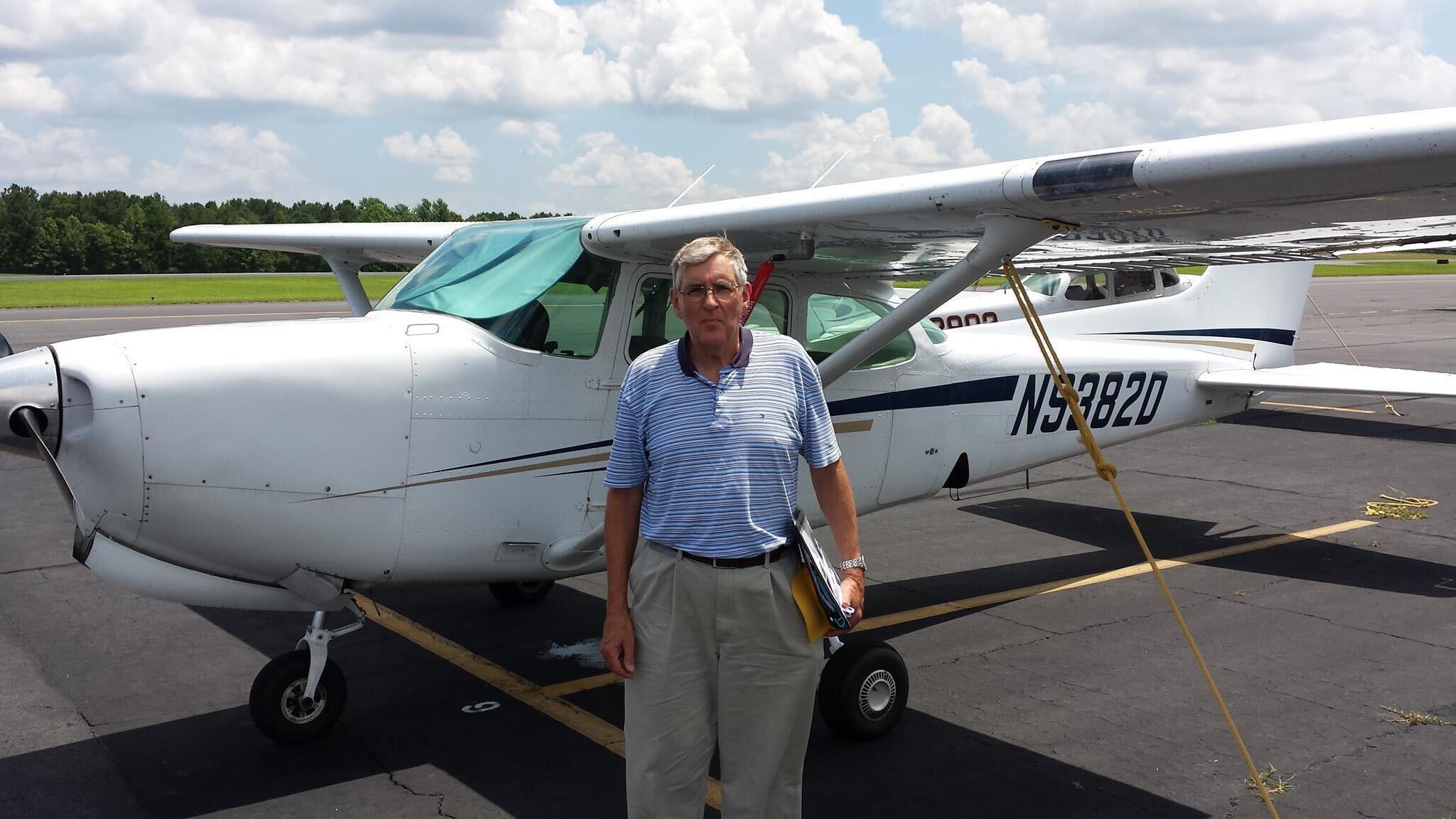 Man stands in front of small plane.