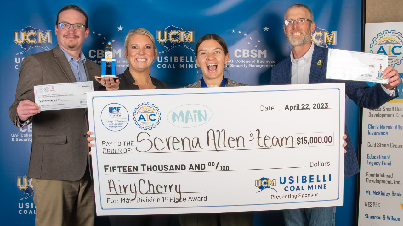 Serena Allen holds up giant check after winning AIC.
