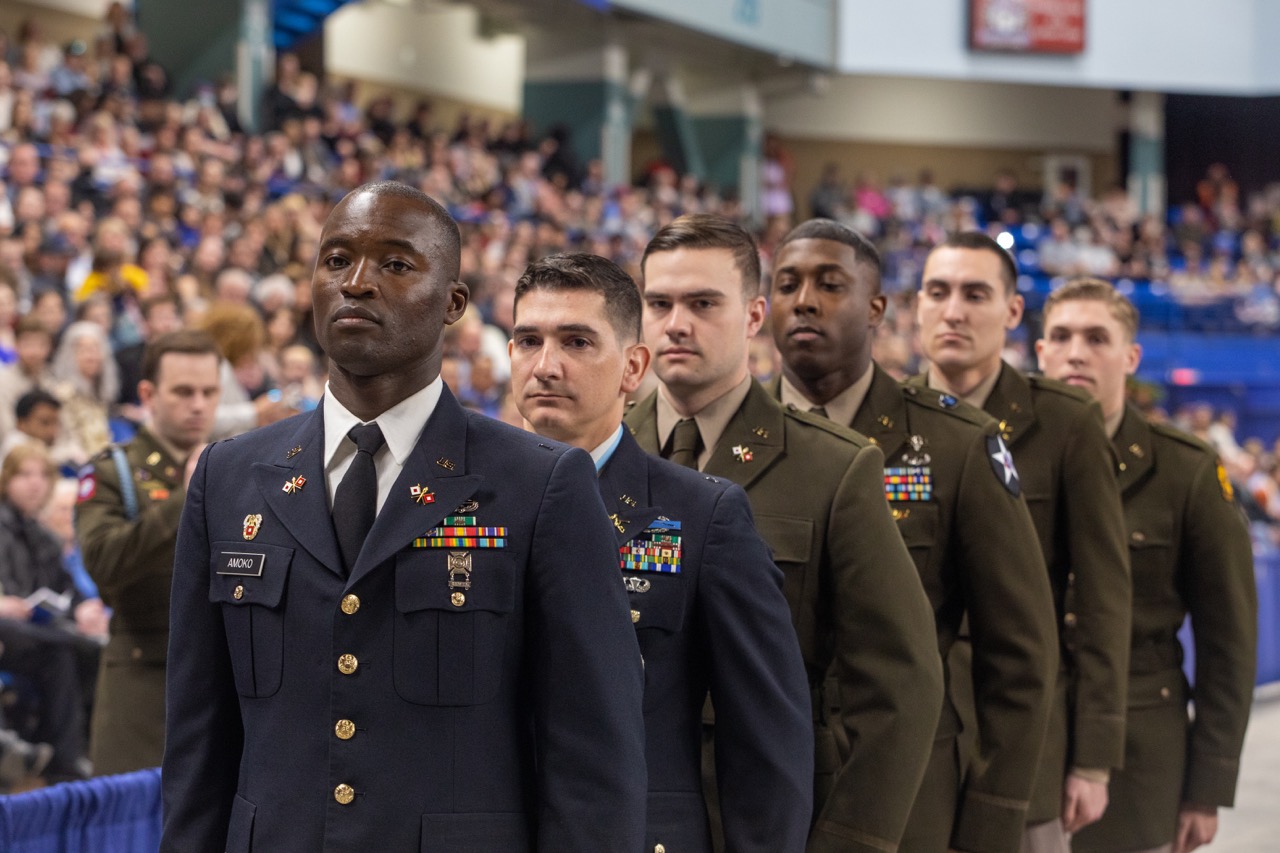 six military officers in uniform walk at UAF commencement