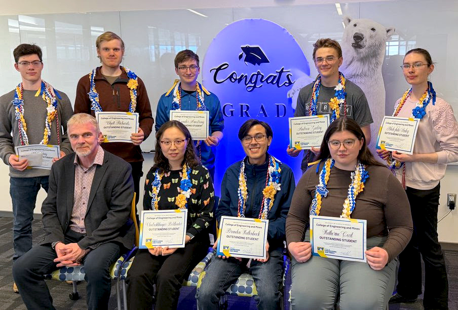 The nine UAF College of Engineering and Mines 2026 Outstanding Students are holding their awards and are joined by the CEM dean.