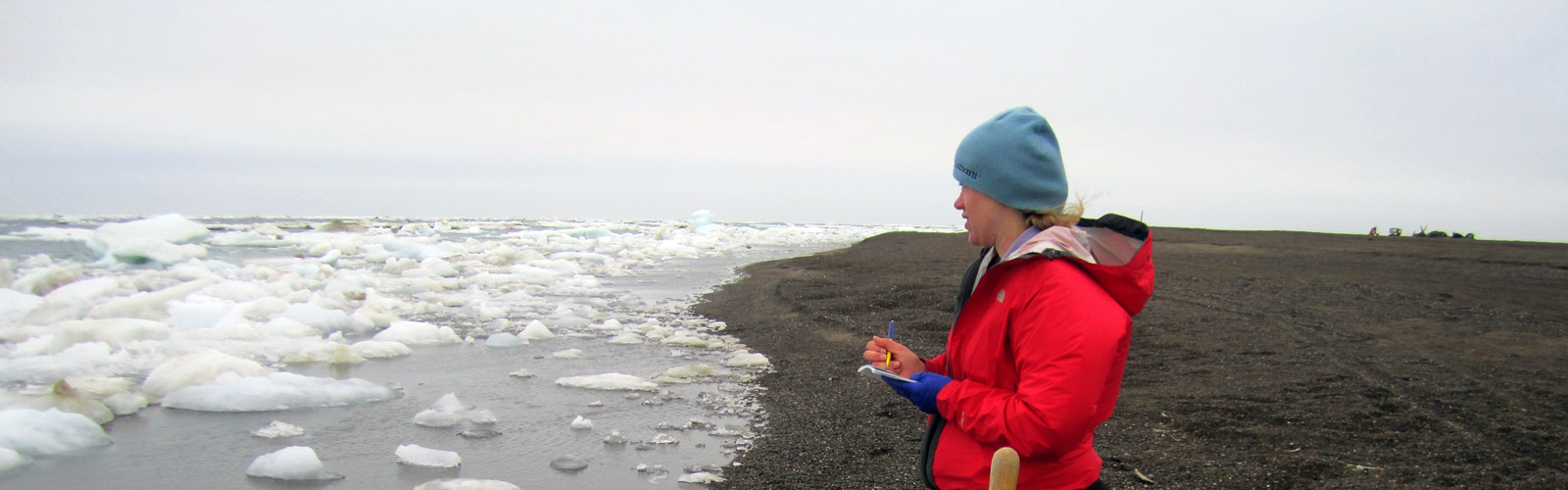 Graduate student observing ice along a shore.