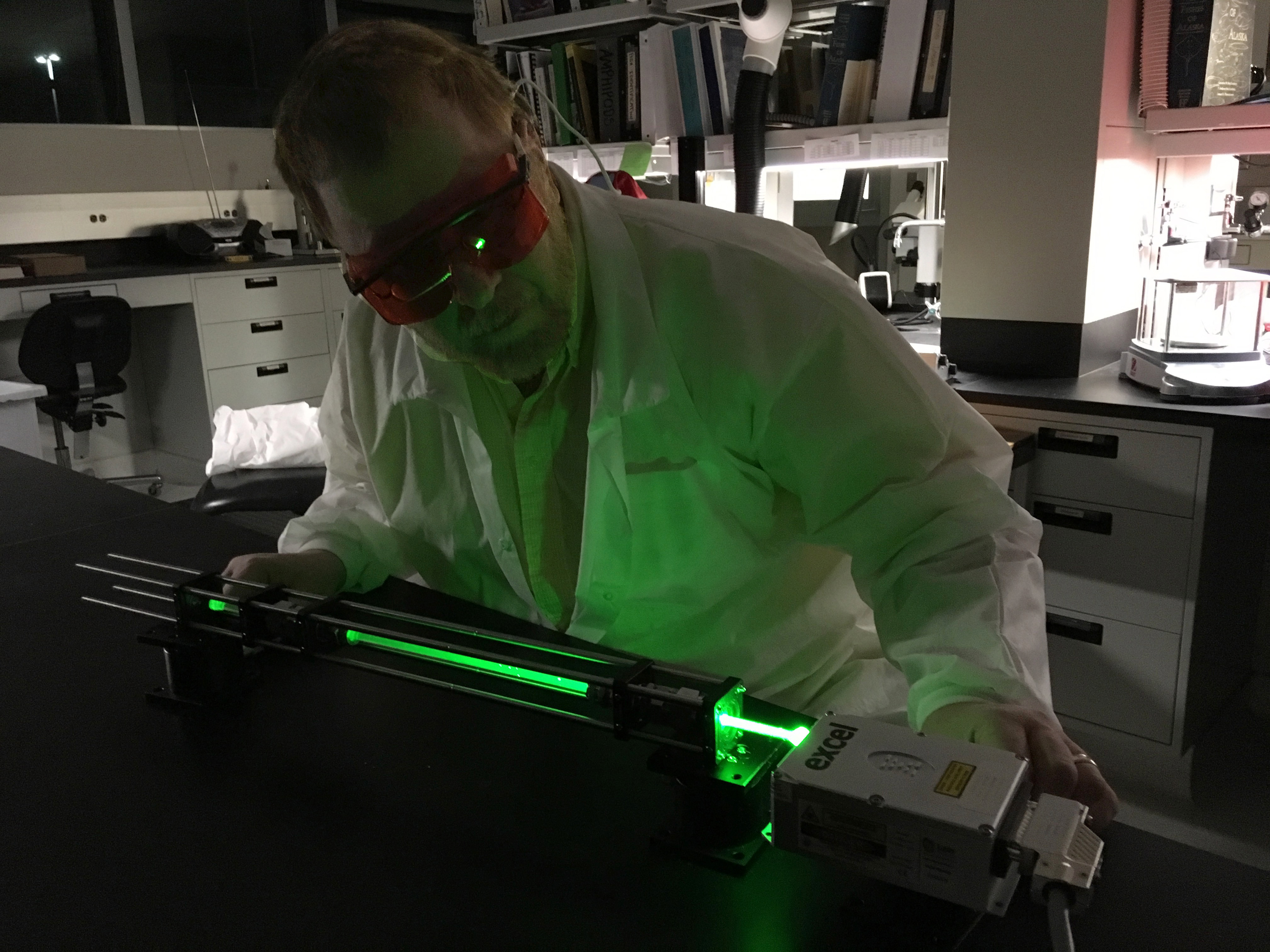 Wearing eye protection against an intensely green laser, Jonathan Kamler examines a new, not-yet-silvered, capillary.