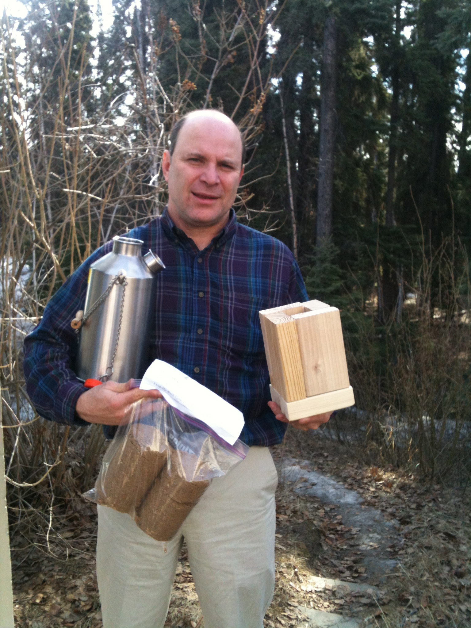 Art Nash shows a commercially produced Kelly Kettle, homemade firelogs and a 2-by-6-inch stove. Photo by Julie Stricker