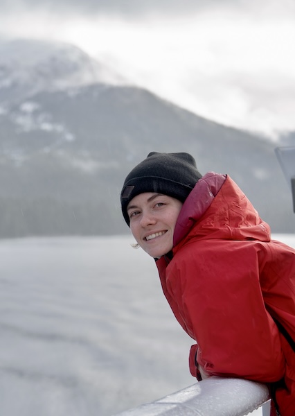 Photo of Alex Jenkins standing on the side railing of a ship