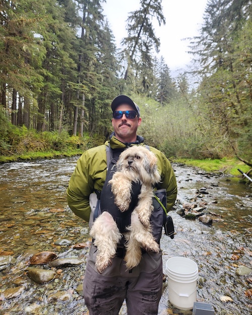 Generic Placeholder Nate Cathart standing in stream with a dog strapped to his chest