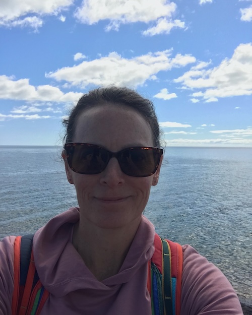 Photo of Rebecca Lavier, smiling with an ocean behind her