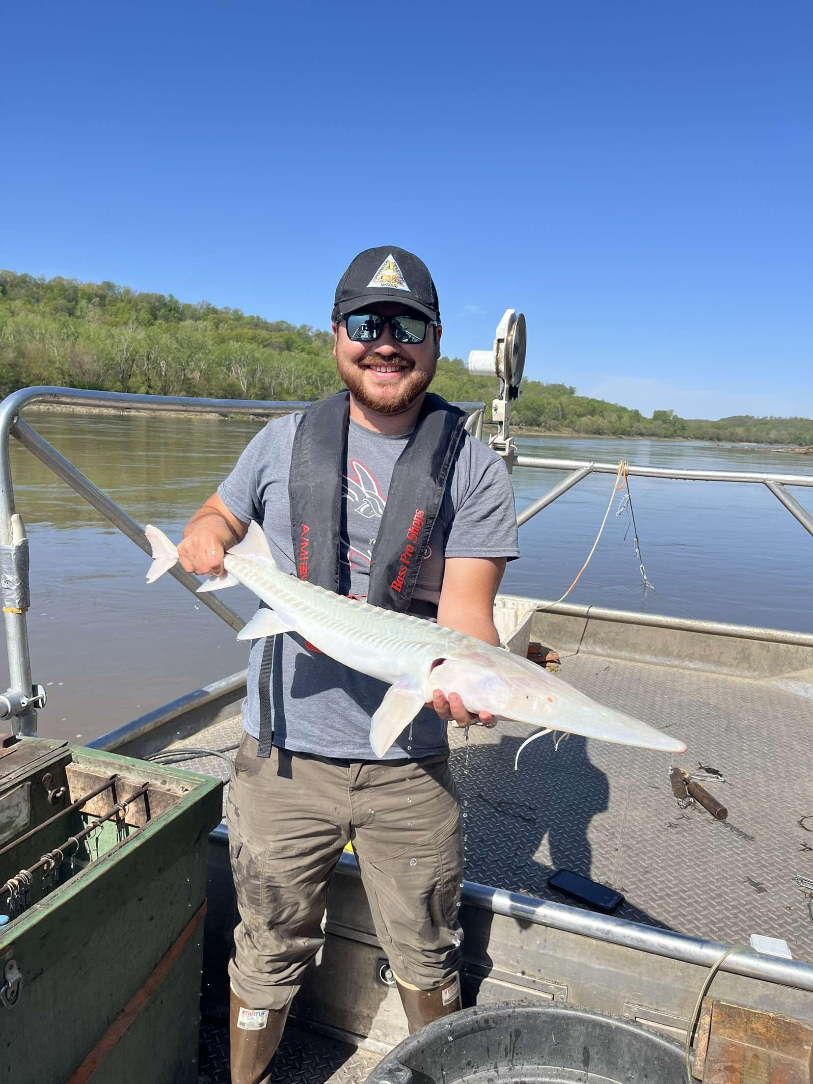Jacob Tsikoya holding a pallid sturgeon fish