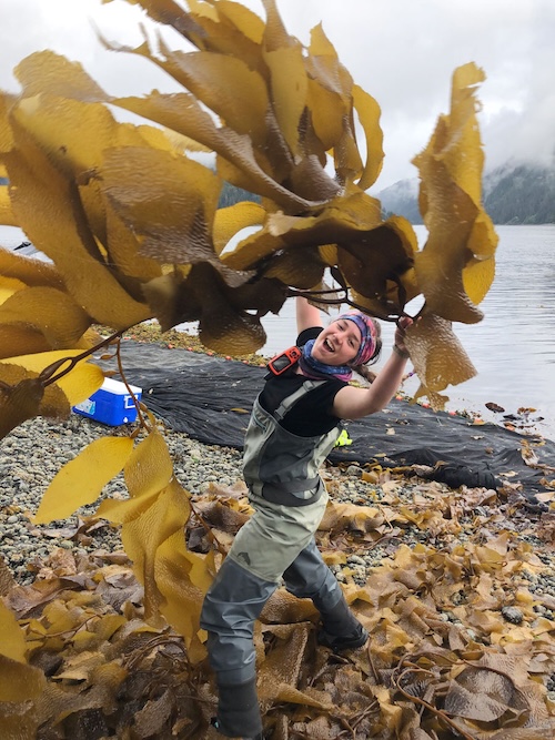 Photo of young woman throwing seaweed toward the camera